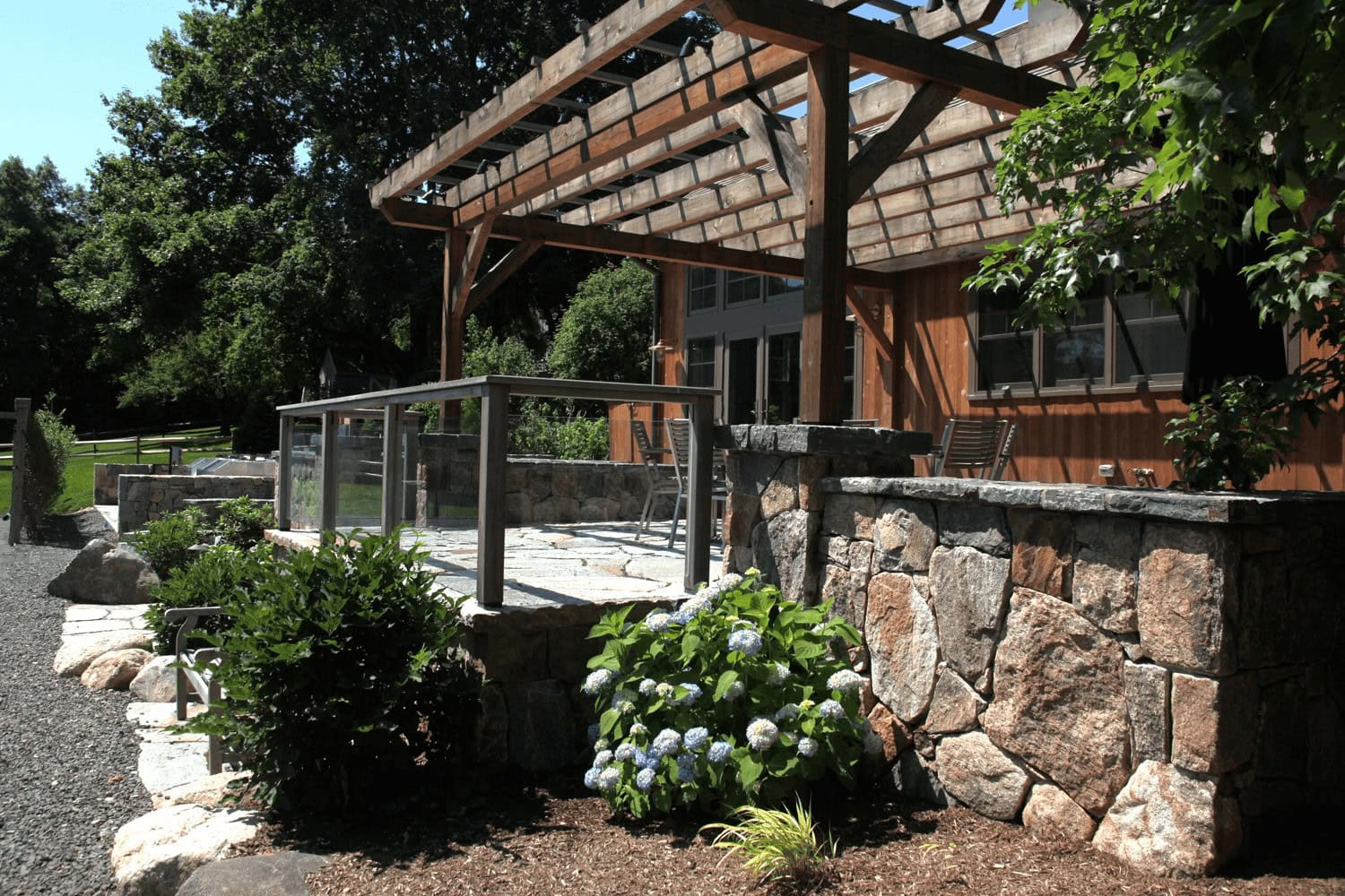Stone wall house with wooden gazebo in luxury garden