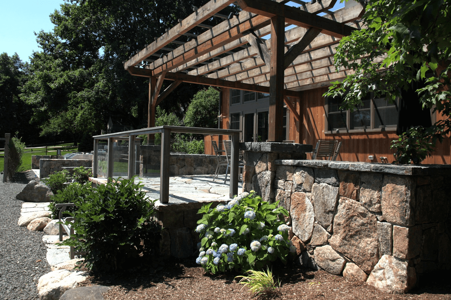 Stone wall house with wooden gazebo in luxury garden