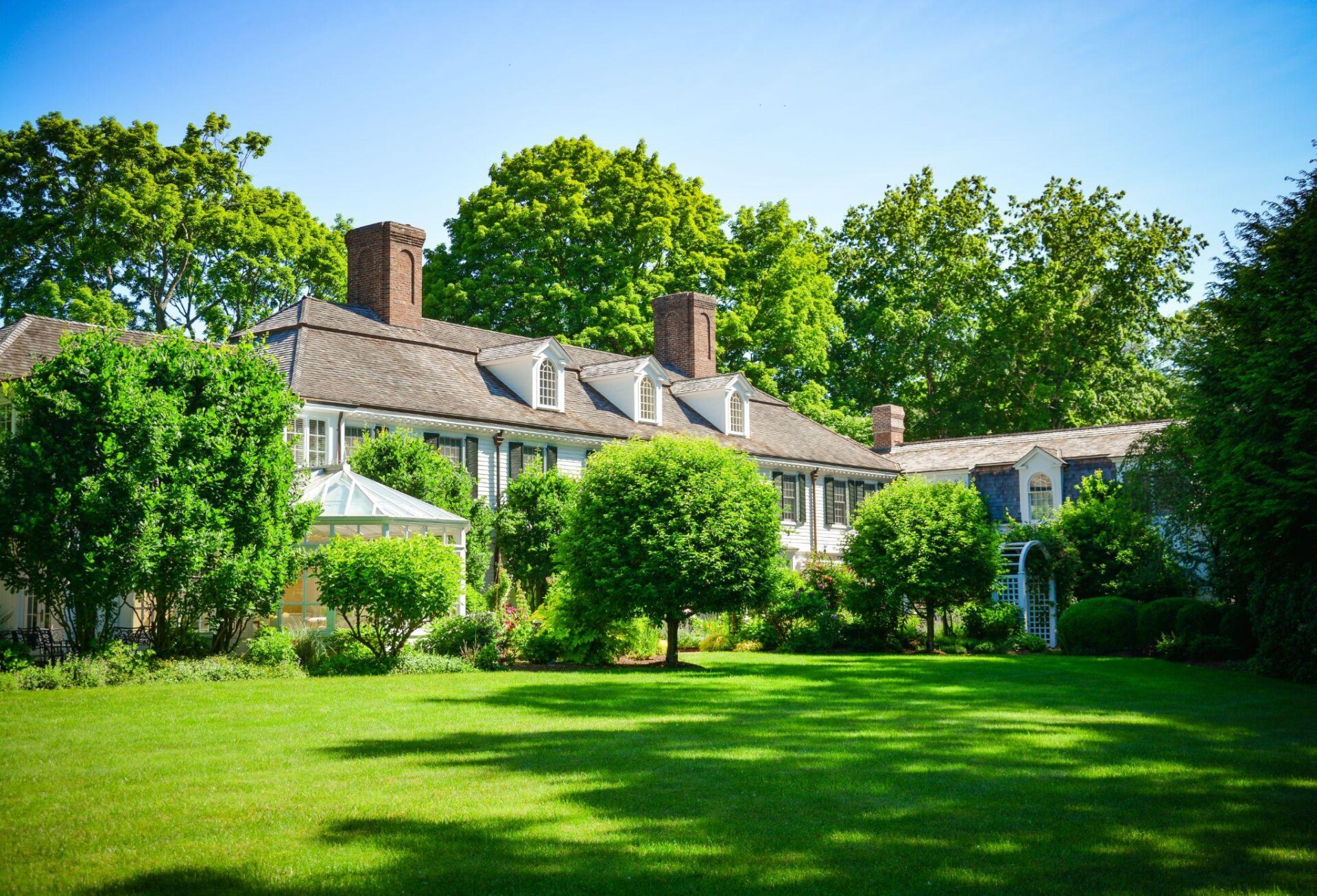 Traditional estate landscape with open lawn and mature shade trees